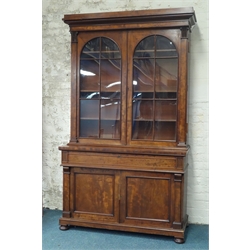  Large Victorian mahogany bookcase on cupboard, raised arched astragal glazed doors, sliding hinged writing slop within frieze drawer, panelled cupboard, turned feet, W148cm, H243cm, D59cm  