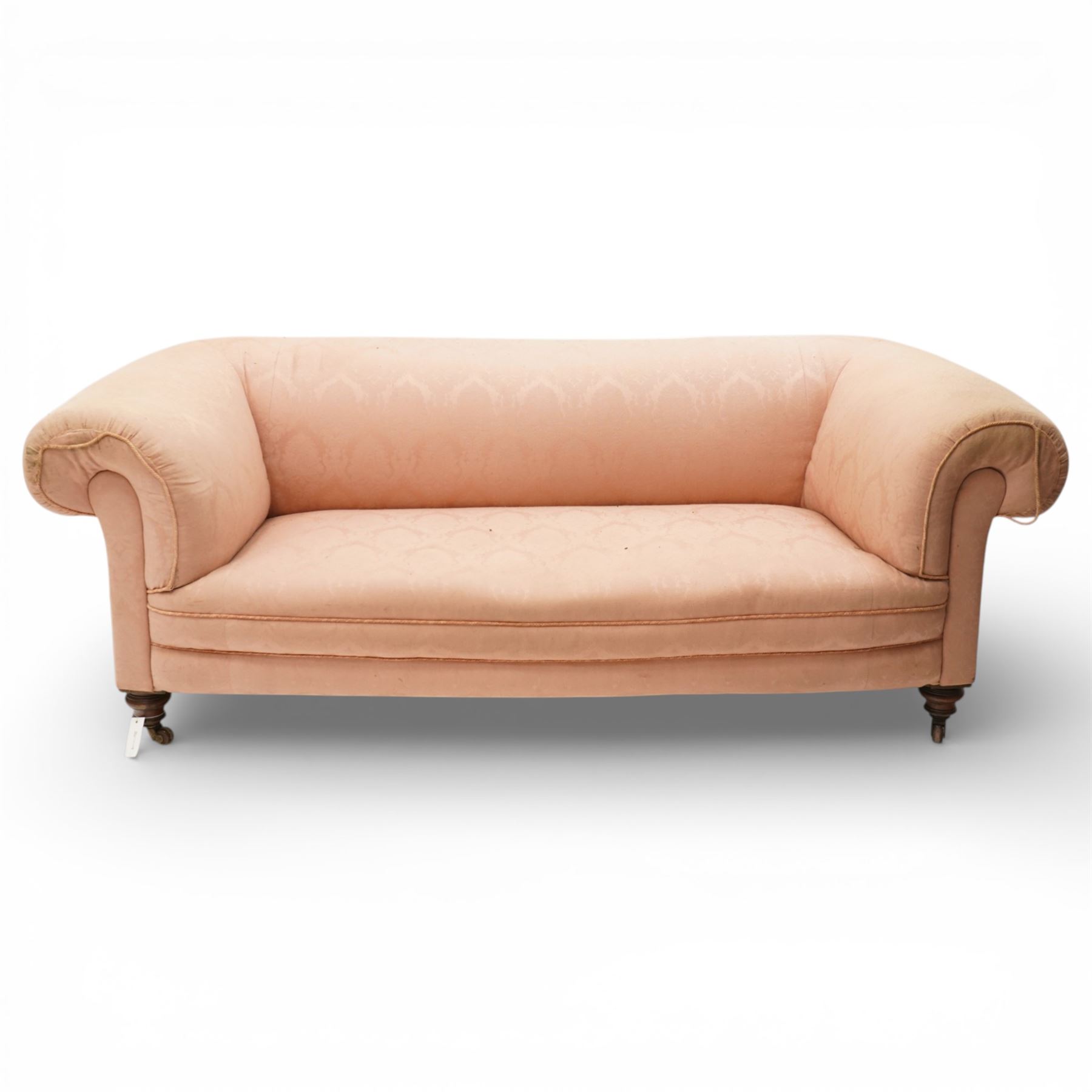 Victorian two seat sofa, upholstered in pink fabric, bowed form with scroll back and arms, raised on turned legs with castors