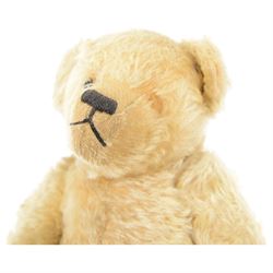 Early 20th century musical teddy bear, with golden mohair head and body, pronounced clipped muzzle, humped back, one eye, black/brown stitched nose, mouth and claws, swivel head and jointed limbs, containing pressure operated musical mechanism, L51cm

Notes by vendor repute: Previously owned by Dame Christian Howard of Castle Howard and given by her in the 1960s to the vendor who was the child of her house keeper.