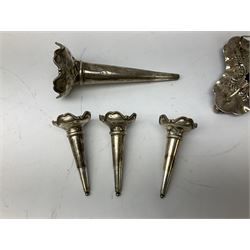 Four hallmarked silver trumpet vases, total weight 108g, upon silver plated stand with foliate decoration and bun feet