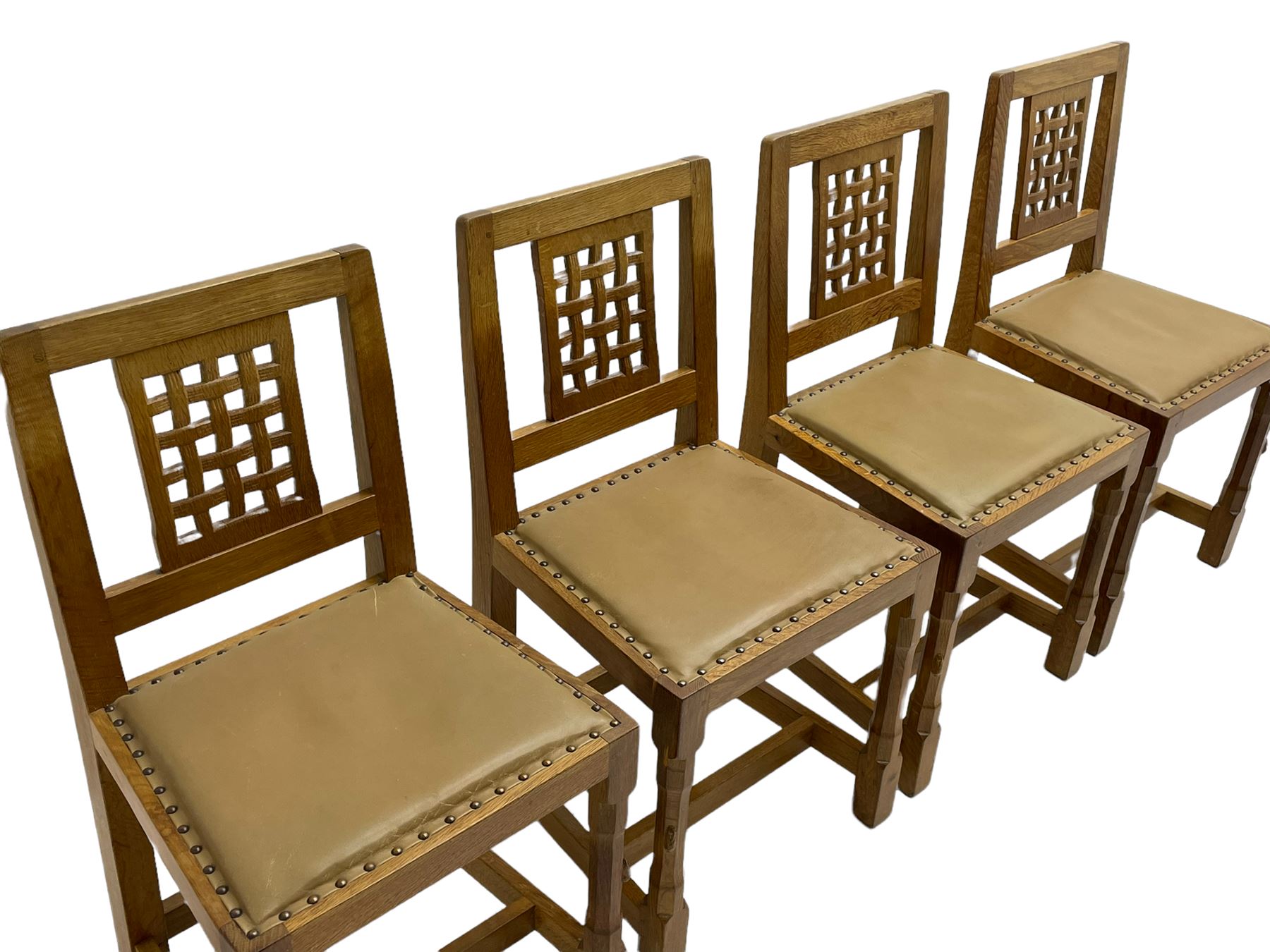 'Rabbitman' set of eight oak dining chairs, pierced lattice backs, upholstered seats with studwork band, octagonal front supports joined by stretchers, carved with rabbit signature, two carvers and six side chairs, by Peter Heap of Wetwang