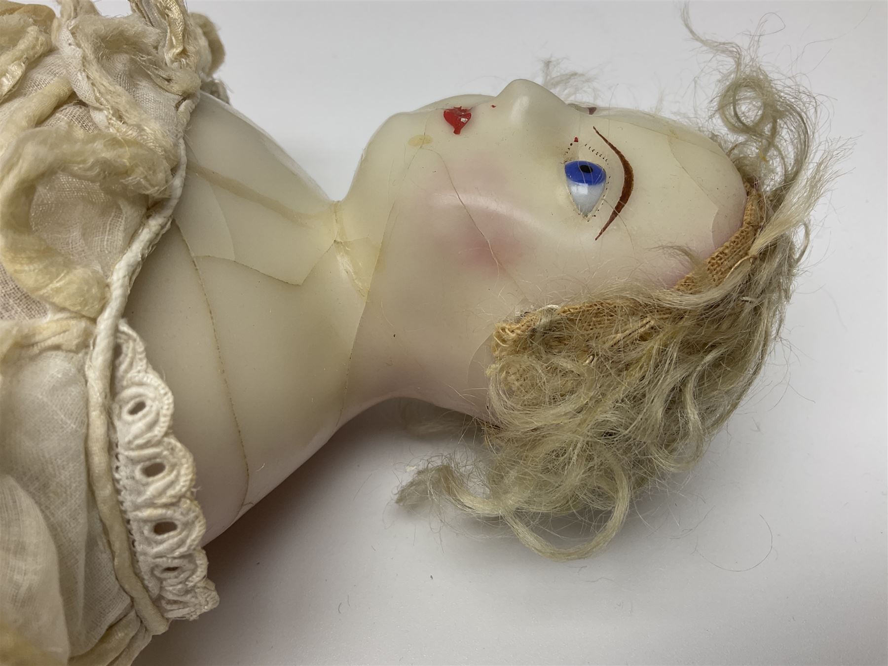 Victorian wax shoulder head doll with pale complexion, applied hair, inset glass eyes and fabric covered jointed body with kid leather lower arms; white linen dress and undergarments H50cm