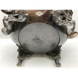 Japanese bronzed koro, the body of globular form with twin cast zoomorphic mask handles, decorated in relief with birds upon blossoming branches, against a ground incised with rushes and peonies, the flat toped domed cover with pierced band and surmounted by a cast figure of a Foo dog, the whole upon three zoomorphic mask feet, with impressed character type mark beneath, H35.5cm