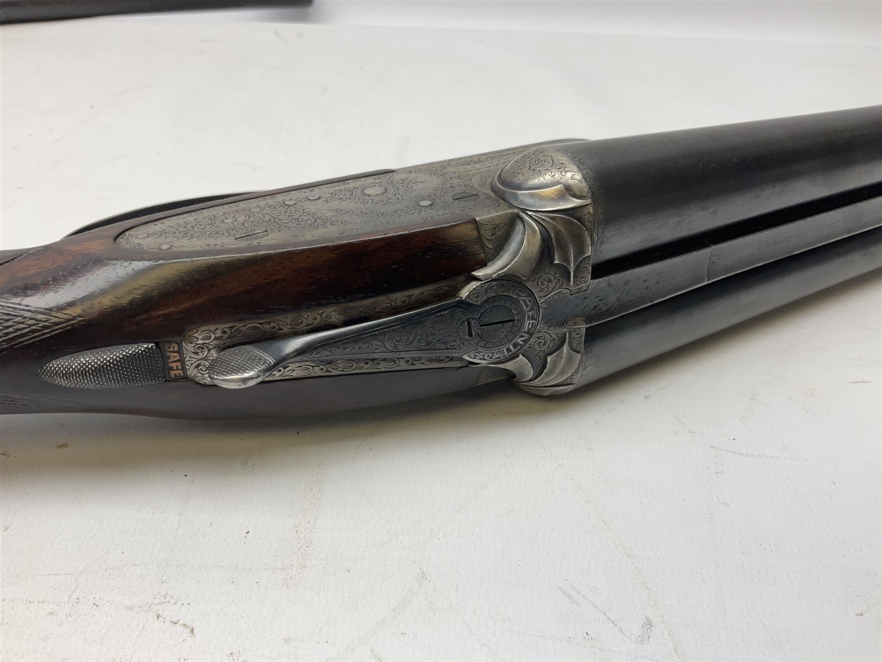 Smith Midgley Bradford 12-bore side-by-side double barrel side-lock ejector shotgun with 71cm barrels, engraved action with patented top lever, ivy leaf fences and top safety, walnut stock with chequered grip and fore-end, serial no.62409 to barrels and 1481 to action, L115cm overall SHOTGUN CERTIFICATE REQUIRED