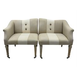 Pair of contemporary hardwood corner chairs, upholstered in broad alternating bands of neutral-toned fabric, each with two knotted rope buttons to the backrest, the whole raised on turned and lightly whitewashed supports terminating in castors
