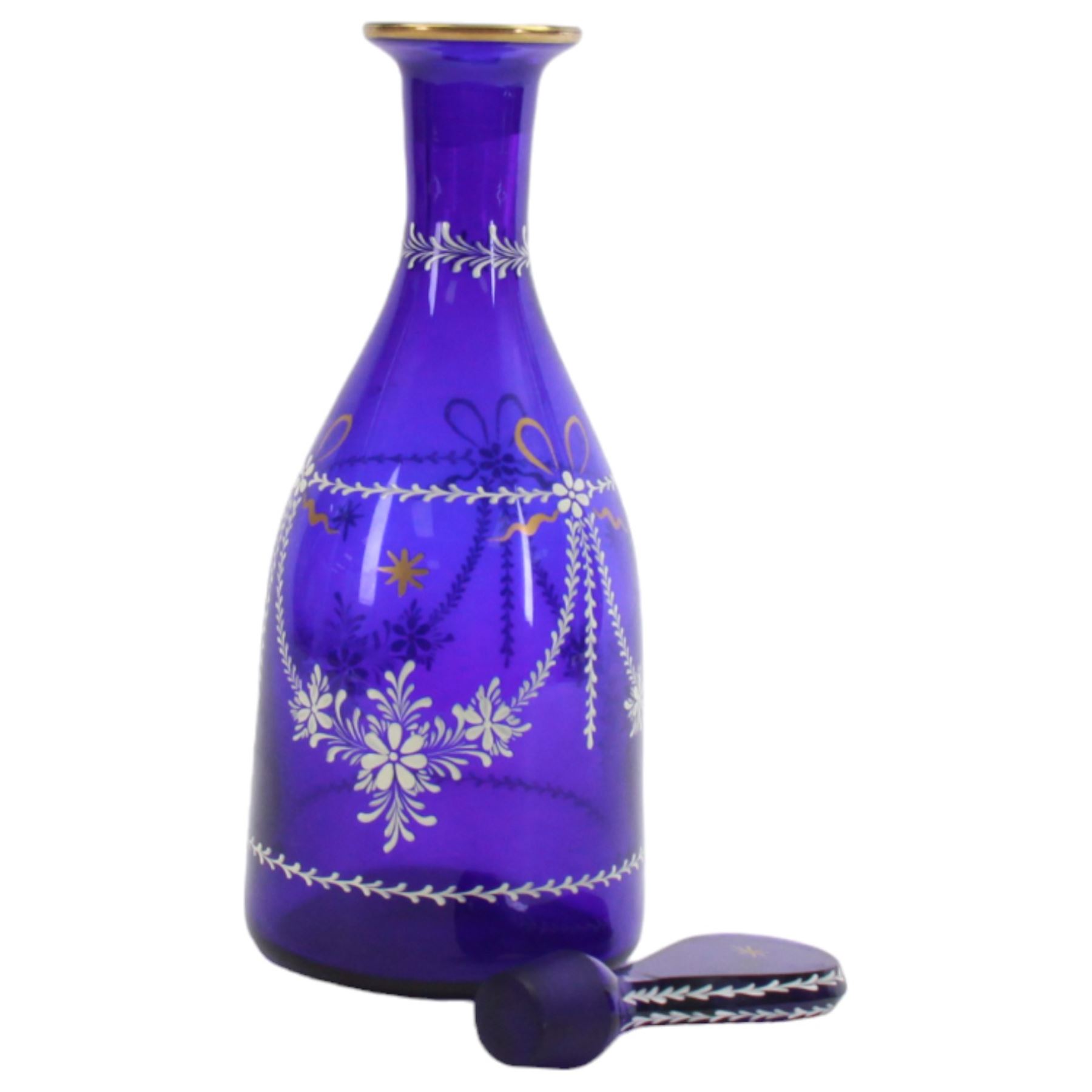 19th century style blue glass decanter and six drinking glasses, the decanter of mallet form with lozenge shaped stopper, all with white enamel and gilt swag decoration, decanter H34cm, drinking glasses H11.5cm