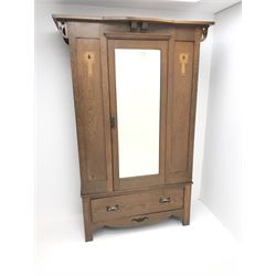 Arts and Crafts period oak wardrobe, projecting shaped cornice, single bevel edged mirrored door above drawer