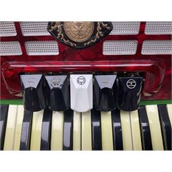 Hsinghai Studio piano accordion with red pearline finish, twenty keys and seventy-two buttons W44cm; in hard carrying case with additional The Music Room soft gig case