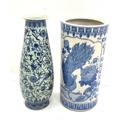 A Chinese blue and white umbrella stand, of cylindrical form decorated with birds perched upon blossoming branches H45cm, together with a Chinese tall blue and white vase of tapering form, decorated with birds amongst foliate tendrils, character mark beneath H46.5cm.