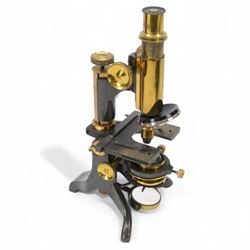 Early 20th century brass microscope, with black lacquer finish by C. E Baker of High Holborn, with lenses and plates contained within a wooden case, together with a collection of prepared microscope slides of predominantly histological and botanical specimens, contained within a wooden case
