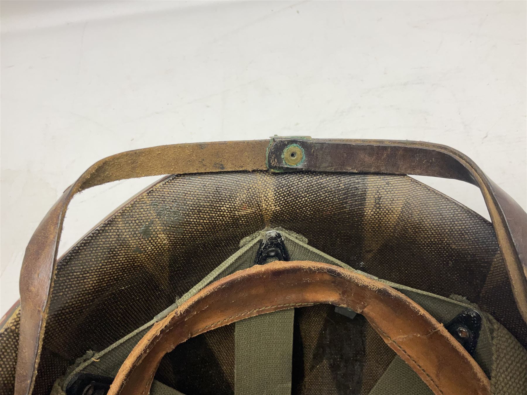 American first type paratrooper helmet with post-WW2 strap and D-rings and later 1944 liner bearing Firestone Tyre and Rubber Company mark; green textured finish