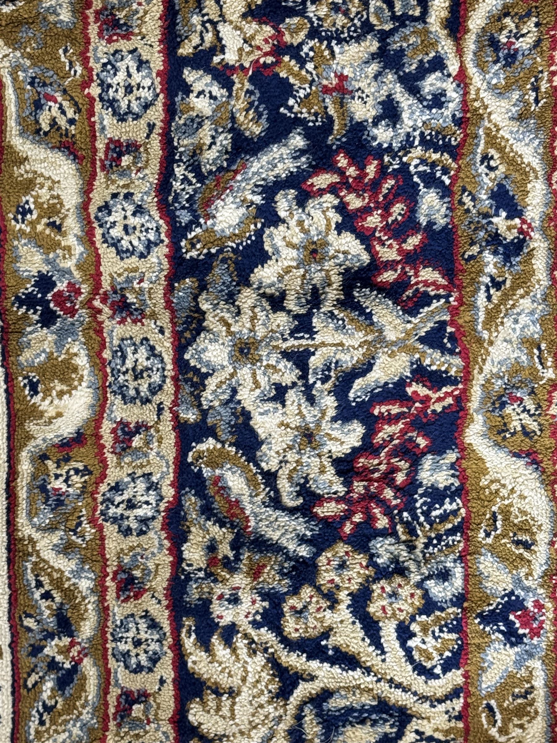 Persian Kerman ivory ground rug, the field adorned with naturalistic depictions of birds, animals and floral designs, framed by a multi-band border in blue and red tones