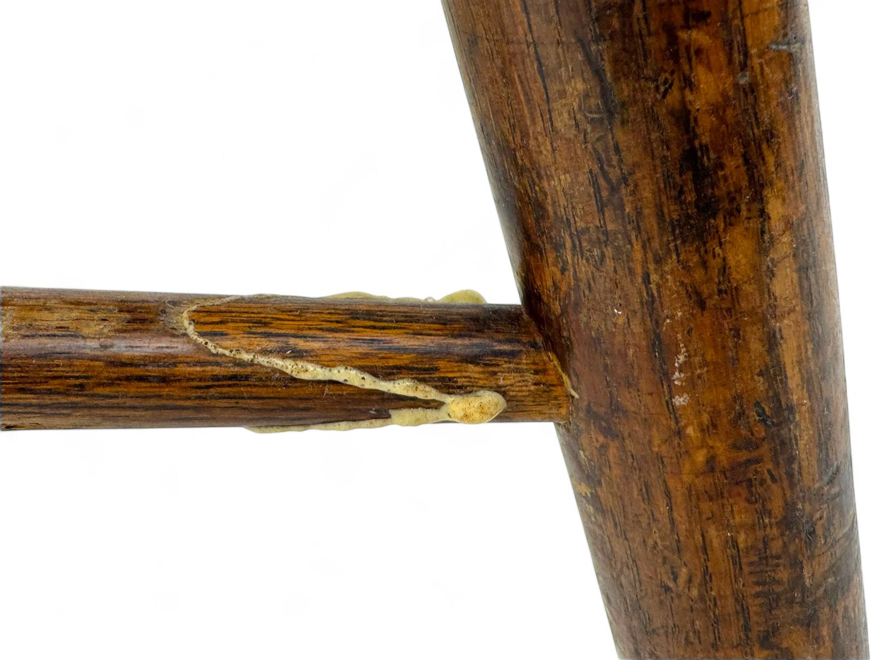 Early-to-mid 19th century elm and ash high-back Windsor armchair, central vase-shaped splat flanked by slender vertical spindles, outward-curving arms, shaped and dished saddle seat, raised on turned and splayed supports united by H-stretcher