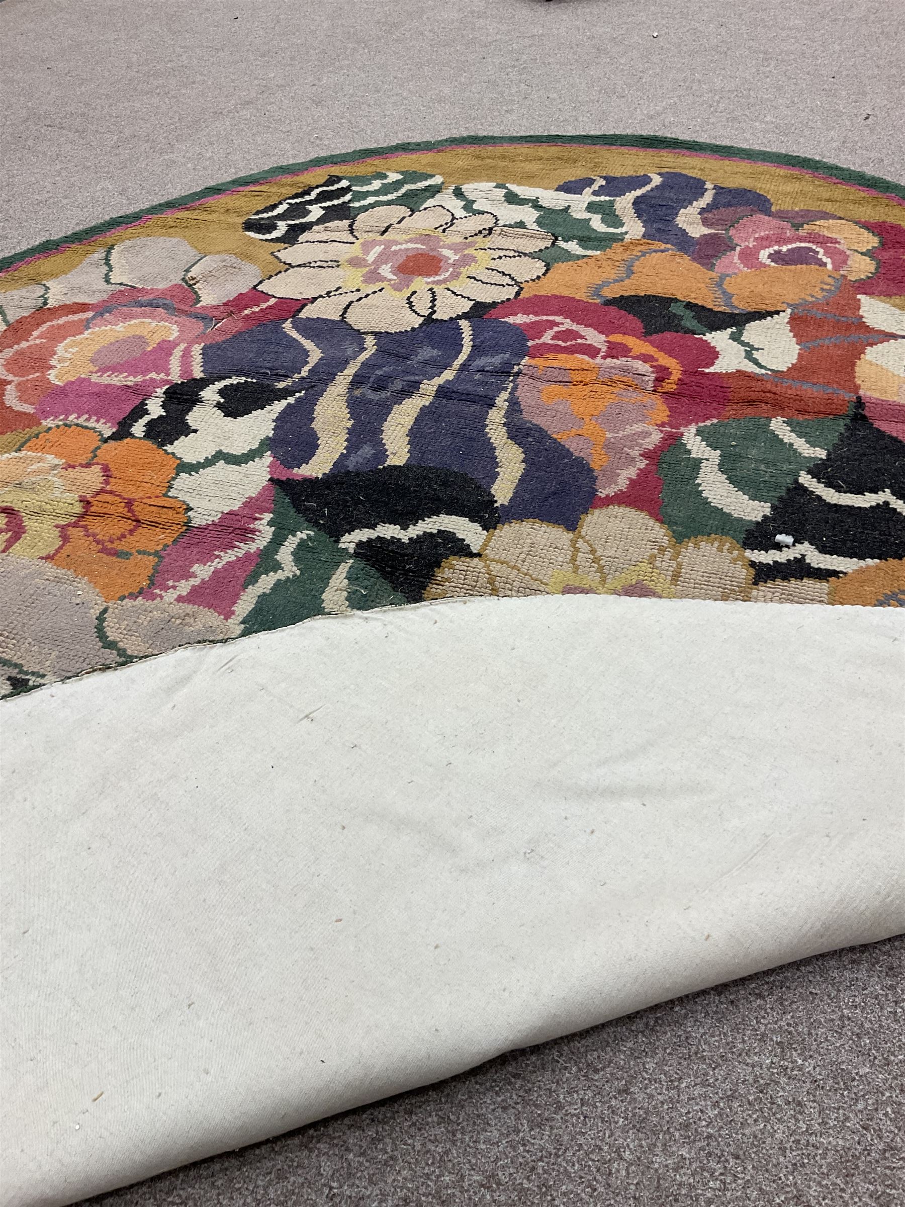 20th century wool oval rug, mustard ground and decorated with flower heads, with pink and green outer bands