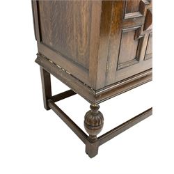 Early 20th century oak sideboard, raised stepped arch back over moulded rectangular top, fitted with two drawers and two panelled cupboards with geometric mouldings, on turned and lobe carved baluster feet united by stretchers 