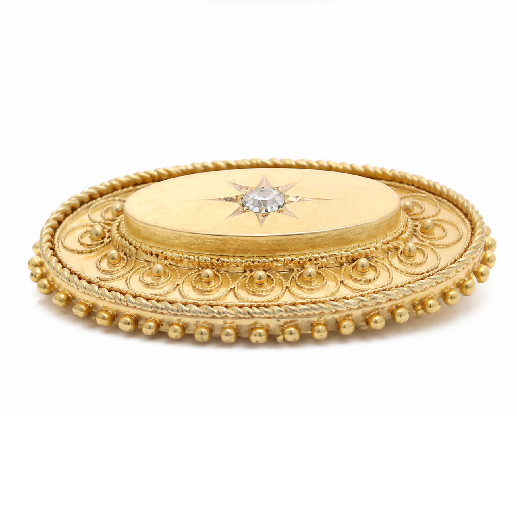 19th / early 20th century gold Etruscan Revival oval brooch, set with a single old cut diamond of approx 0.20 carat, surrounded by wirework and bead decoration, stamped 15ct