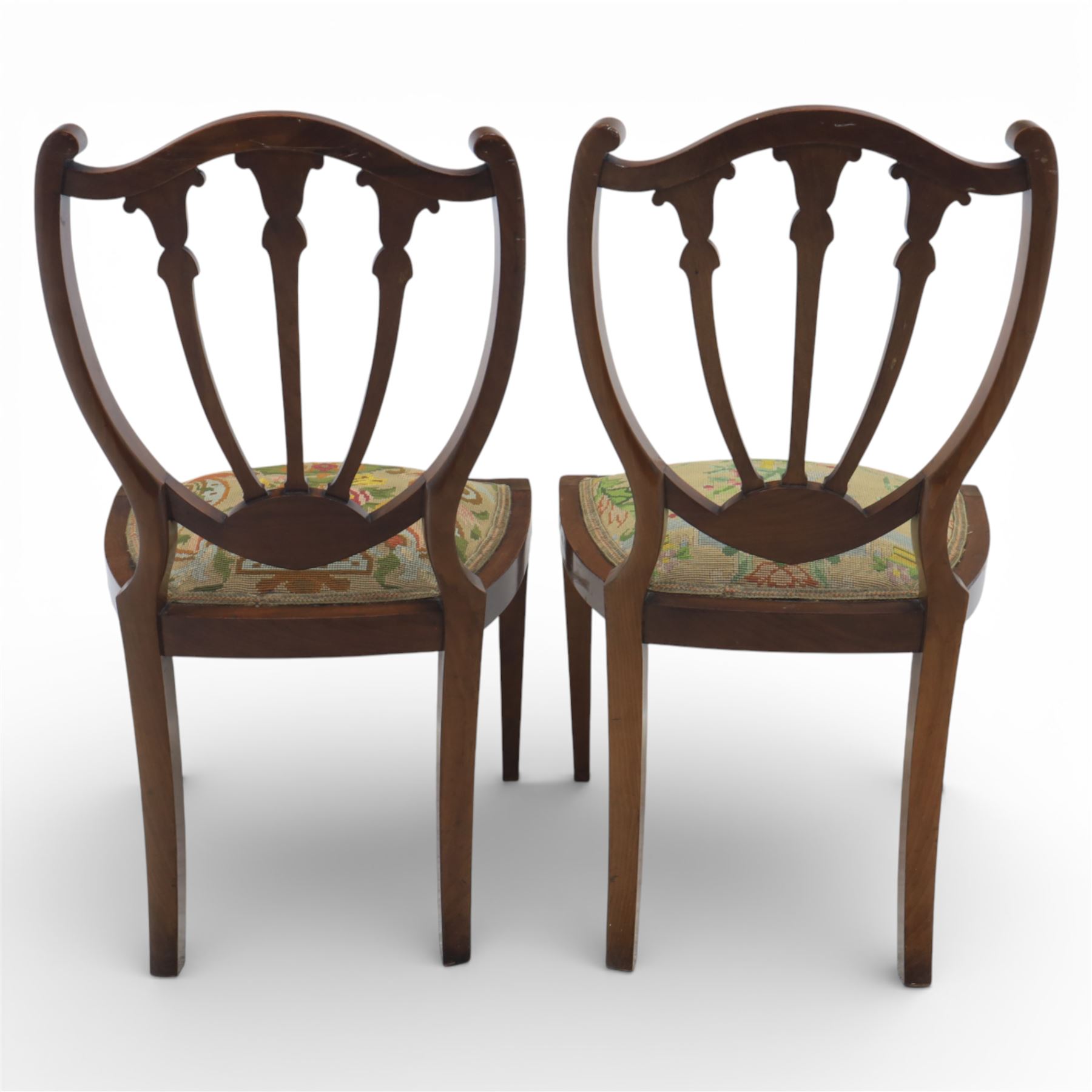 Edwardian pair of satinwood inlaid shield back chairs, the pierced shield shaped backs with central splats inlaid with floral and foliate motifs, tapestry upholstered serpentine seats, raised on square tapering supports