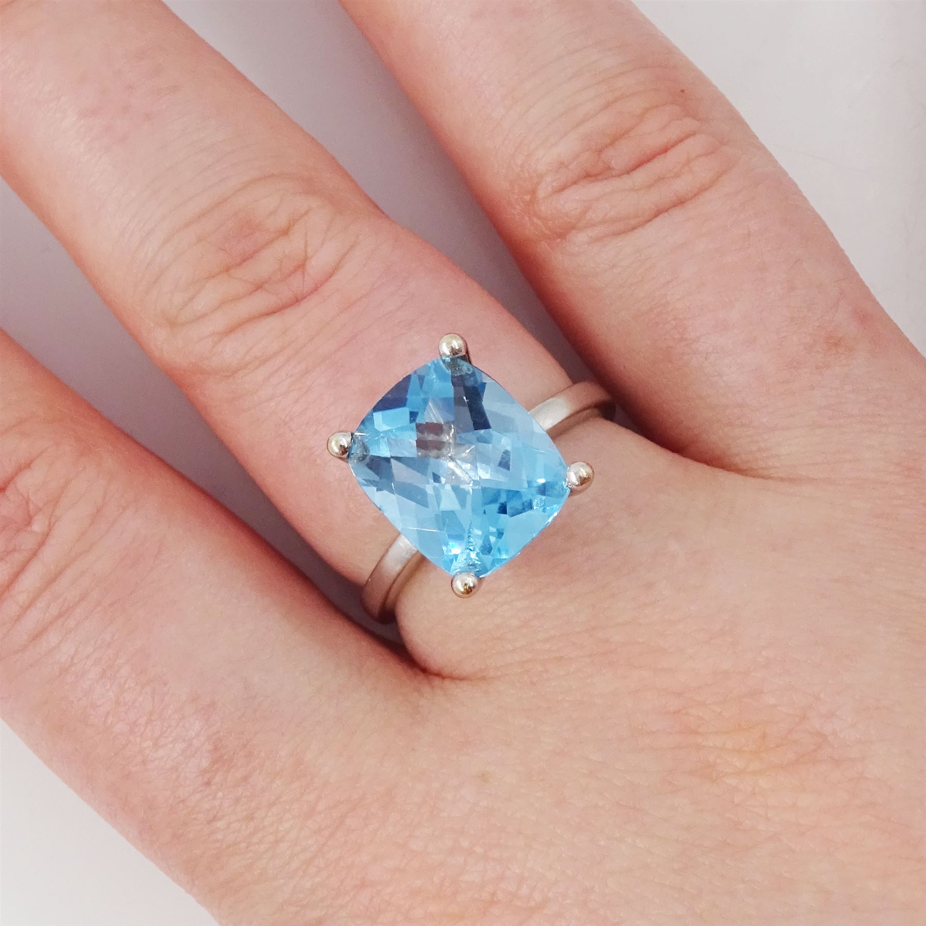 18ct white gold blue topaz ring, four claw set with a single cushion briolette cut Swiss blue topaz, hallmarked
