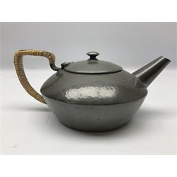 Liberty & Co Tudric pewter three piece tea service, comprising teapot with woven reed handle, twin handled open sucrier, and milk jug, each of squat form with planished finish, each impressed beneath Tudric Pewter Ware 01537 Made in England, together with a matched unmarked tray