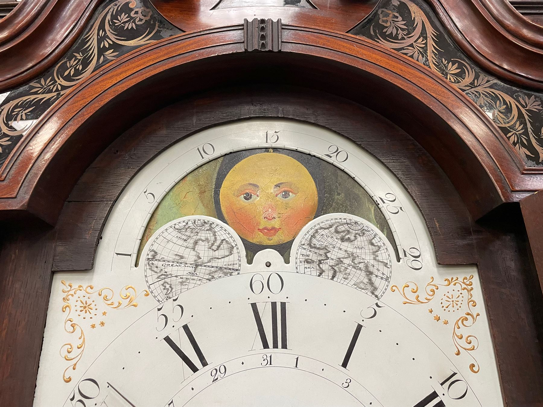 Penlington of Liverpool – early 19th century 8-day mahogany longcase clock, swans neck pediment with three turned wooden finials and verre eglomise panels, trunk with reeded columns and wavy topped door, plinth with canted corners on bracket feet, painted break-arch dial with Roman numerals and five-minute Arabic’s, centre sweep calendar and seconds hands, blue steel serpentine hands, signed beneath a painted rolling moon in the arch PENLINGTON, LIVERPOOL, eight day four pillar movement, anchor escapement and rack striking on a bell. With pendulum and weights.  The Penlington family were prolific clockmakers in 19th century Liverpool working from several addresses in the city, also recorded as chronometer and chronograph makers.