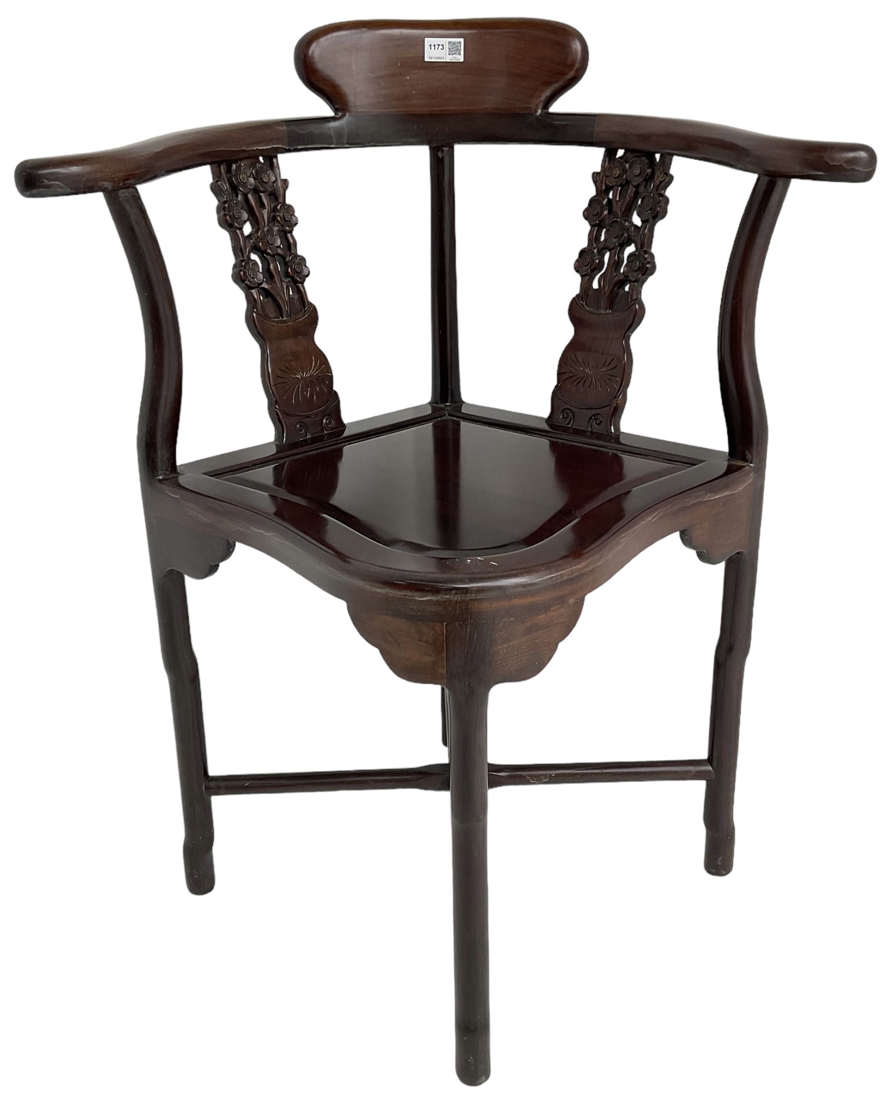 Chinese carved hardwood corner chair, outswept arms over pierced and carved floral splats, raised on shaped cylindrical supports united by X-stretcher