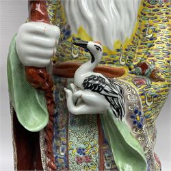 Chinese Republic Period porcelain figure, modelled as Shoulao, wearing elaborately enamelled robes decorated with peaches and flower heads, with impressed mark beneath, H55cm