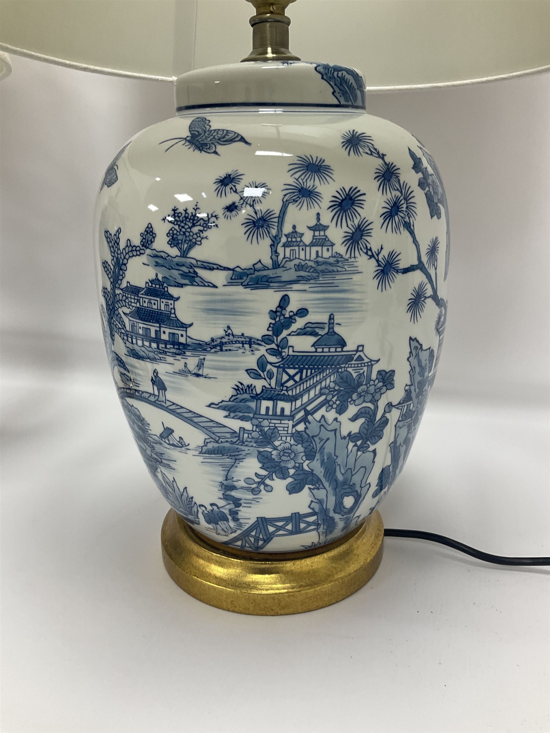 Pair of Chinese table lamps of baluster form, each decorated with landscape scene, raised upon gilt circular base, including shade H63cm