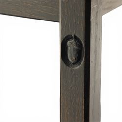 Acornman - dark stained oak two-tier stacking tea trolley, the rectangular removable top, above a second tier raised on castors, with carved acorn signature, by the workshop of Alan Grainger of Brandsby