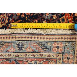 Persian indigo ground Herati rug, the busy field with a central lozenge pole medallion surrounded by repeating Herati motifs, within a shaped spandrel border the crimson guard band decorated with repeating palmette motifs