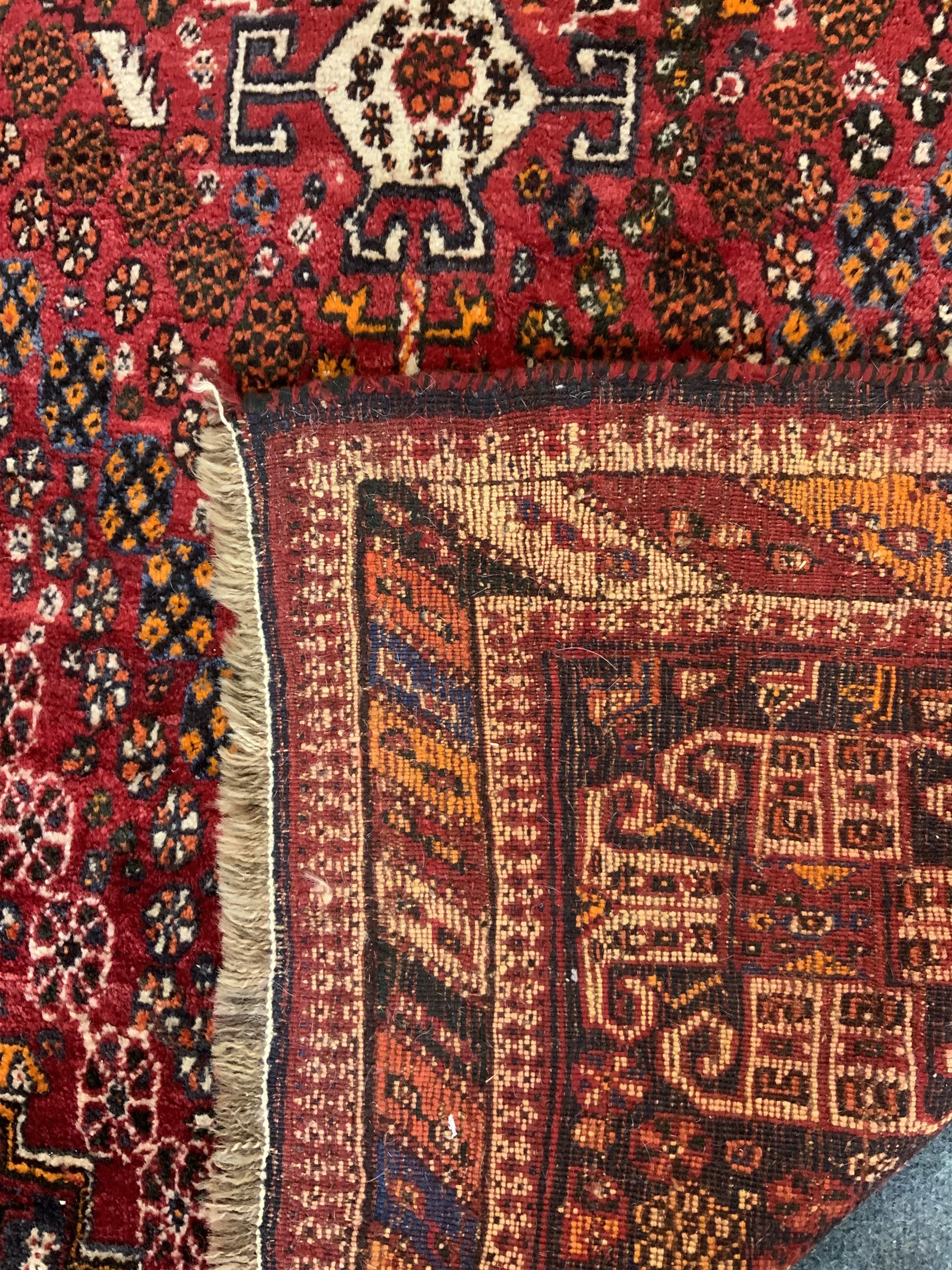 Persian red ground rug carpet, central diamond medallion, multicoloured chequered border