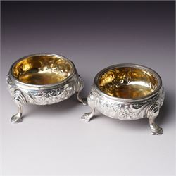 Pair of George III silver circular salts with gilded interiors and embossed decoration and two 19th century condiment spoons, one by Peter and Ann Bateman 