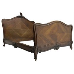 Early 20th century French walnut 4' 6'' double bedstead, the headboard with moulded frame carved with C-scroll shell decorated with foliage, on foliage carved cabriole feet with scrolled terminals