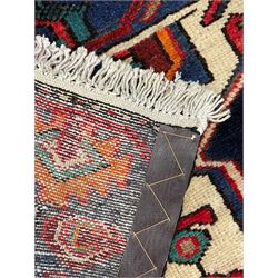 North West Persian Heriz rug, blue and ivory ground, decorated with stylised plant motifs, the border decorated with repeating geometric design 