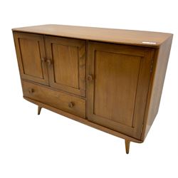 Ercol - elm and beech sideboard, fitted with cupboards and single drawer, enclosed by panelled doors, on splayed tapering feet