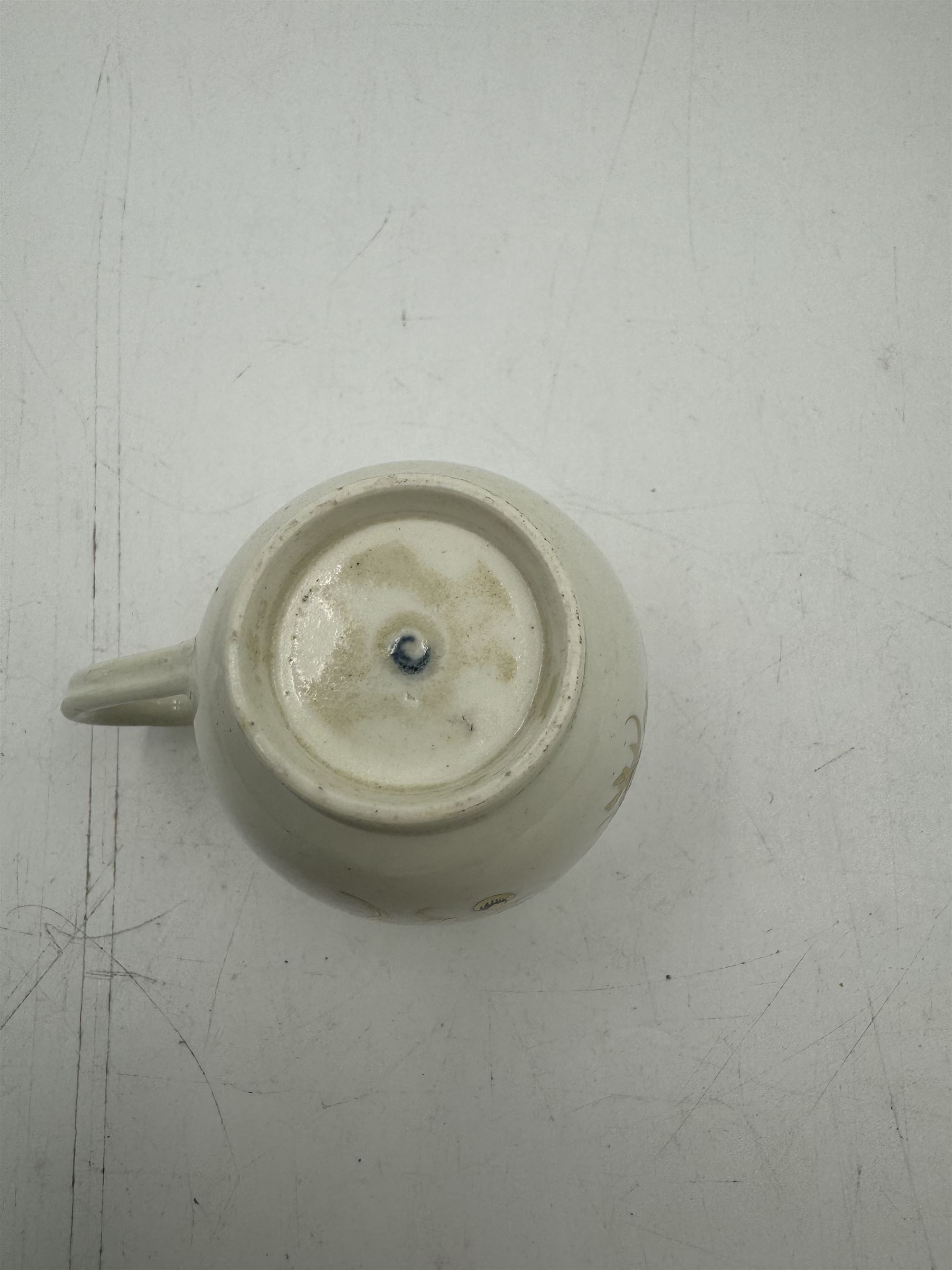 18th century Caughley blue and white sparrow jug, decorated in the Mother and Child pattern, circa 1780-1790, with underglaze C mark beneath, H9cm, together with a Worcester coffee cup, circa 1785 painted with floral sprays in underglaze blue and gilt, with crescent mark beneath, and a Caughley trio of tea cup, tea bowl and saucer, each of moulded wrythen fluted form and decorated with gilt and blue sprigs and bands, each with crescent mark beneath, (5)