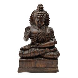 Hand carved wood figure of seated Buddha, modelled in the Vitarka Mudra pose, the head framed by a circular halo and clad in robes upon base, H25.5cm