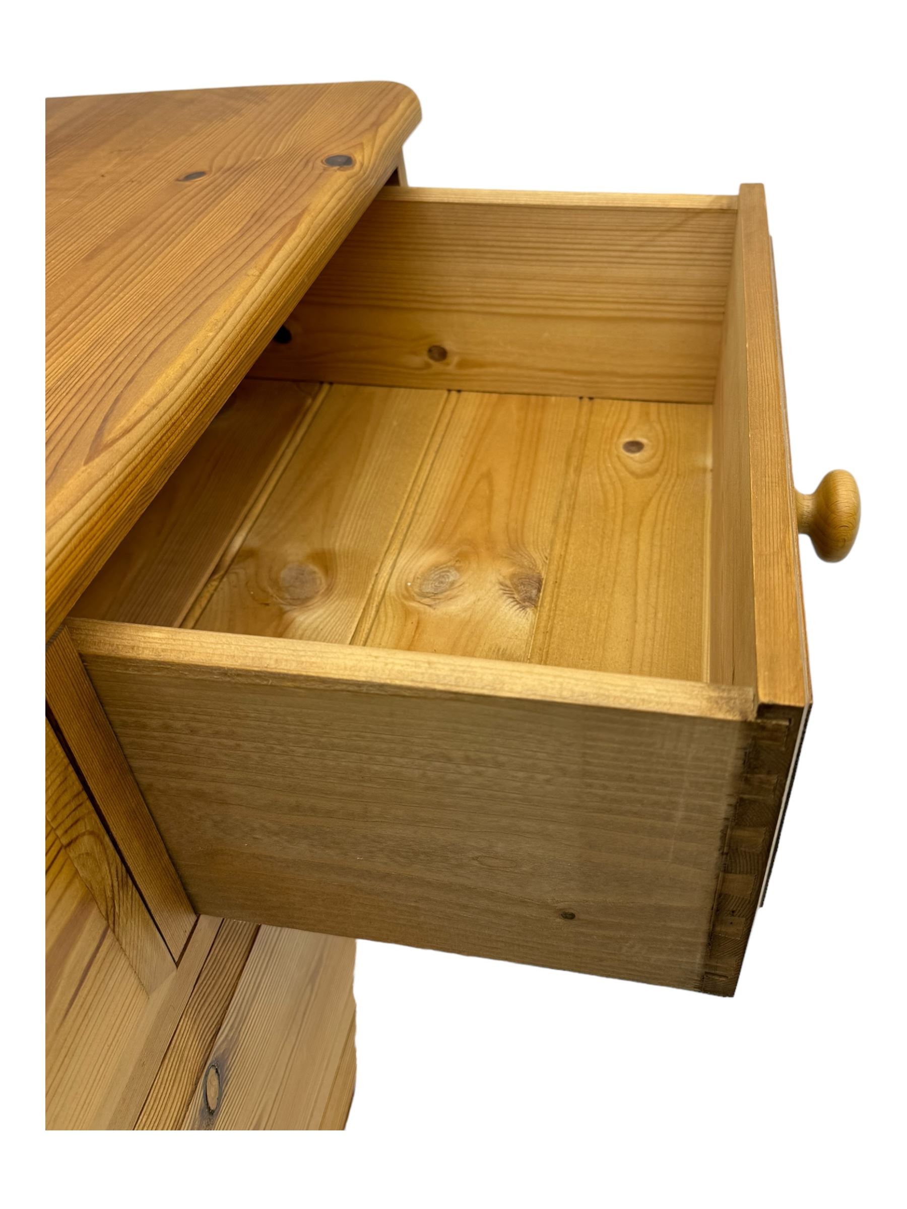 Pine chest of drawers topped with carved pediment with acorn and oak leaf motif, fitted with two short over three long drawers, standing on shaped apron base (W92, D46, H97cm); pine bedside cabinet, single drawer above paneled cupboard door enclosing open storage, shaped plinth base (W43, L32, H67cm)