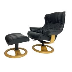 Anderssons of Sweden - mid-20th century design swivel armchair, upholstered black leather, raised on beech U-frame supports with circular base, together with matching footstool 