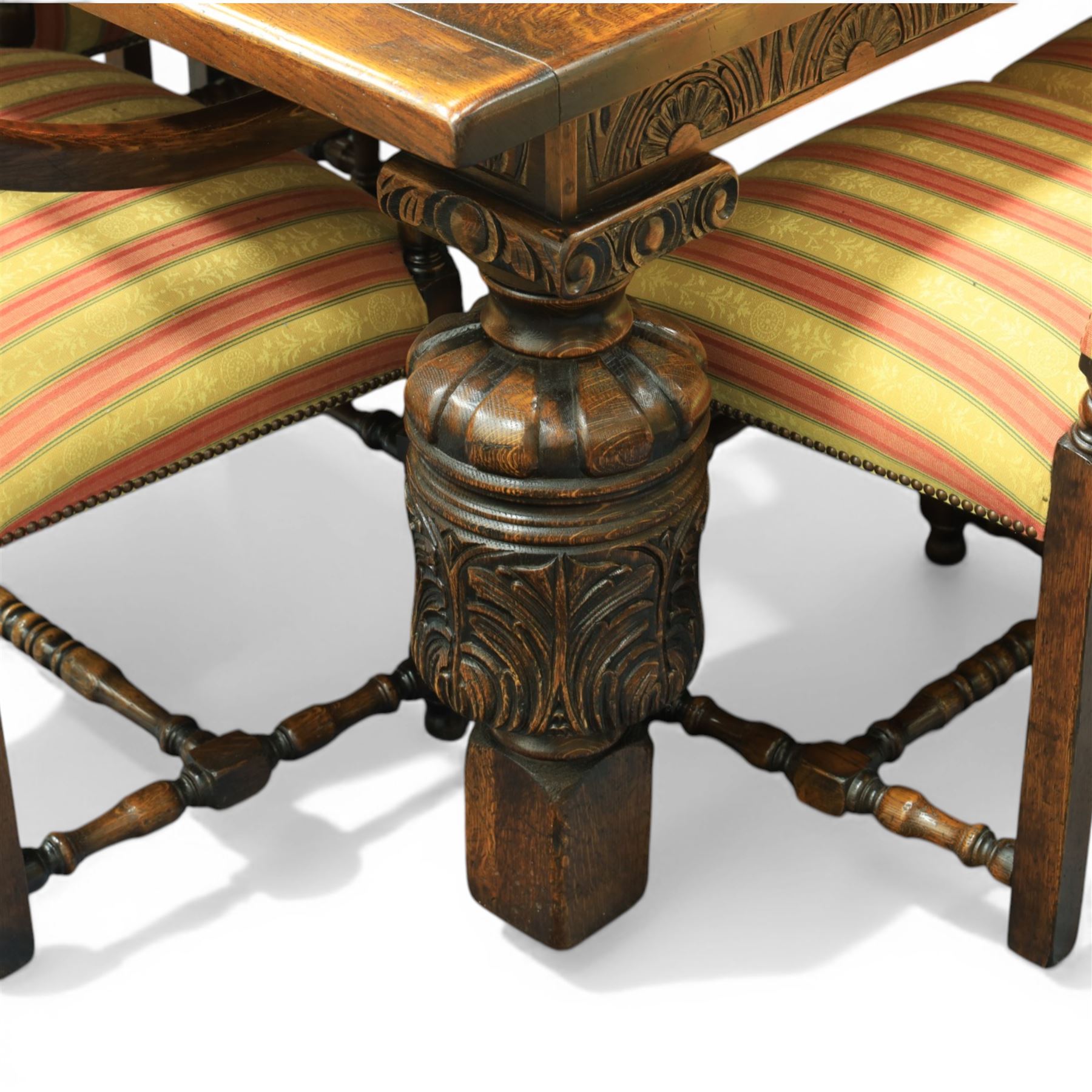 Royal Oak Furniture Co - Jacobean style oak dining table with suite of ten oak high back dining chairs (8+2), rectangular plank top dining table with moulded edge above carved frieze, raised on bulbous turned supports united by stretchers, together with a set of oak framed high back dining chairs including two carvers, upholstered in striped fabric with studded borders, on turned supports united by stretchers 