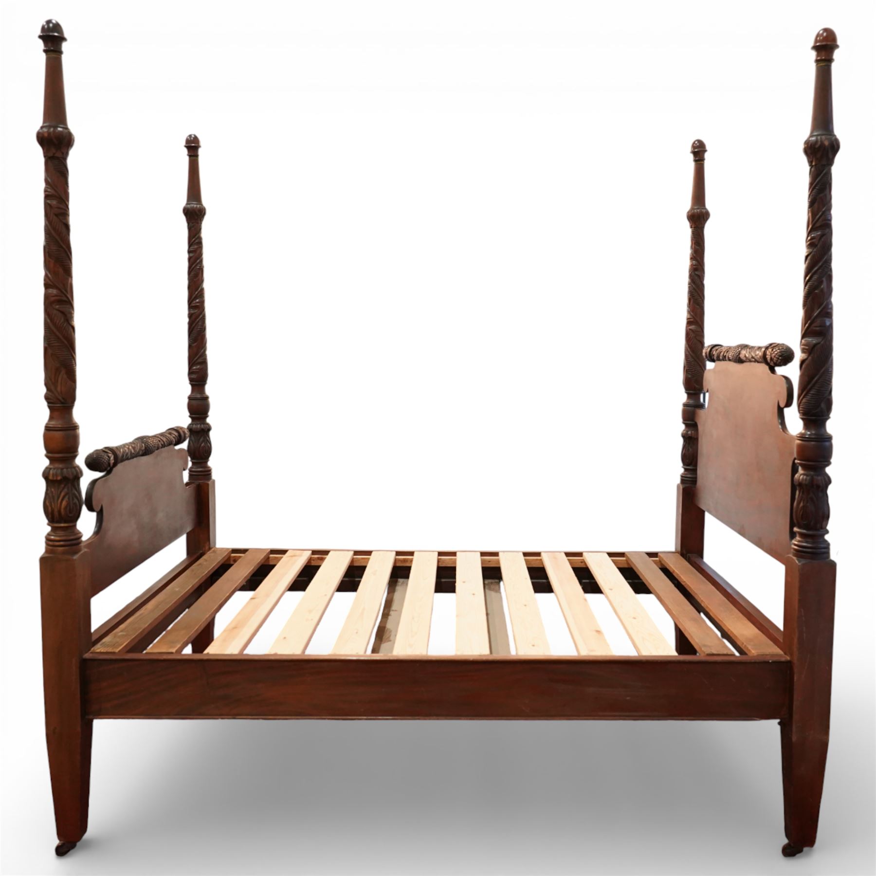 Early 19th century Regency carved mahogany four poster double bed, 4'6, the shaped headboard and footboard each surmounted by a finely carved pinecone and foliate moulded rail, flanked by ring turned and boldly spiral carved tapering posts with acorn finials, raised on square section legs, with slatted base