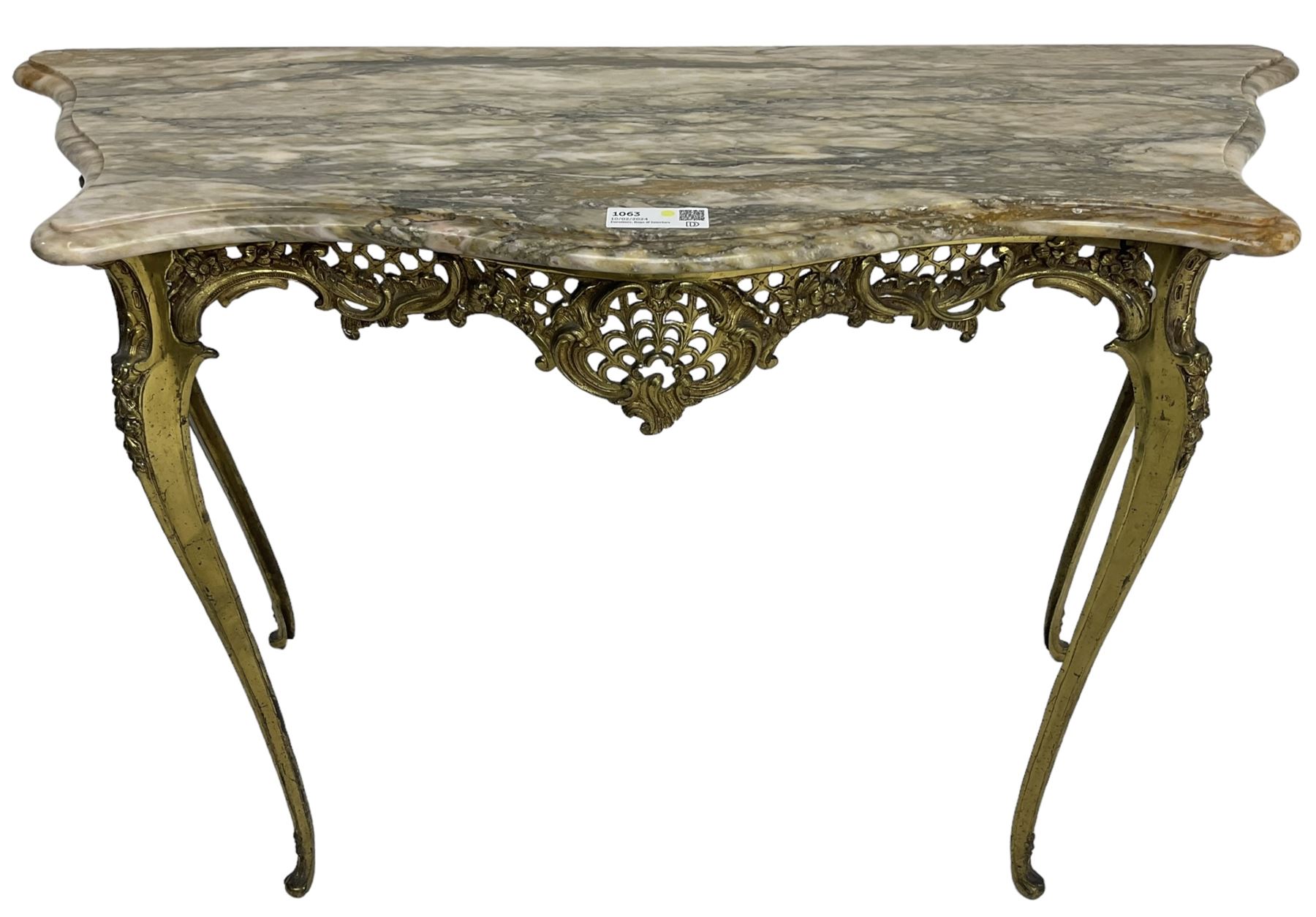 Louis XVI design serpentine front console table, shaped marble top over a cast brass base, the apron pierced and decorated with c-scrolls and foliate cartouche motifs, on cabriole supports with floral patterned knees