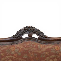 Victorian mahogany framed serpentine sofa, the shaped button upholstered back with central carved foliate cartouche, and scroll arms with carved terminals, over upholstered red seat, upon carved cabriole supports with castors