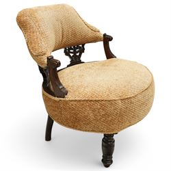 Late Victorian mahogany framed tub shaped chair, curved padded back and overstuffed seat in textured ochre fabric, pierced mahogany back supports with foliate and scroll carving, on turned front legs