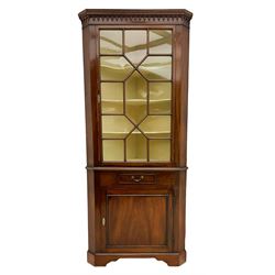 George III mahogany floor standing corner display cabinet, dentil cornice, upper astragal glazed door above small drawer and lower cupboard, on bracket feet, in two sections
