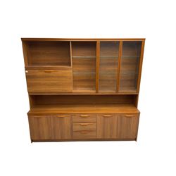 Mid-20th century teak wall unit, fitted with two glass shelves flanked by two glazed cupboard doors and fall-front cupboard, base fitted with three drawers flanked by two double cupboards