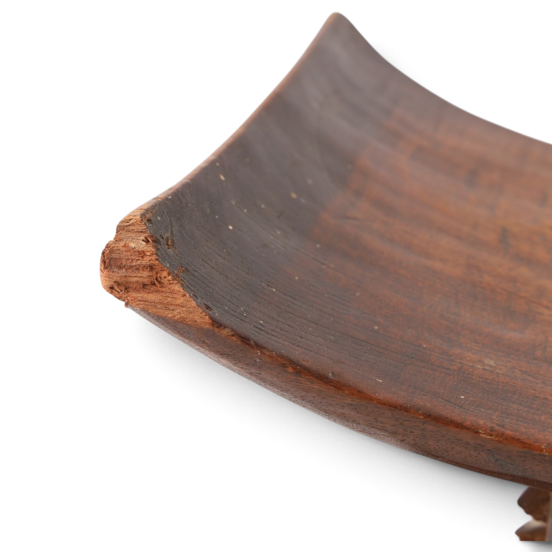 African carved hardwood headrest, having flared edges, raised on a stepped plinth base with further carved detailing, H34cm