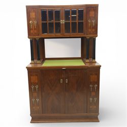 Continental Art Nouveau cocktail cabinet, the stepped cornice over a glazed upper section with panelled doors, enclosing fitted shelf, the central section with mirrored back and green baize serving surface flanked by ebonised and gilt detailed pilasters, the base fitted with cupboard doors inlaid with stylised foliate and geometric motifs, on a plinth base
