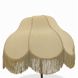 Early 20th century Art Nouveau metal standard lamp, the slender column with adjustable collar, raised on a circular dished base with three pad feet, fitted with a metal gallery and bulb holder, beige raw hide with fringe 