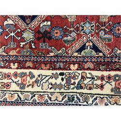 Pair of rugs one Persian hamadan rug central stepped medallion enclosing geometric motifs in ivory and brown, framed by a cream border with scrolling palmettes and fringed ends (H 156cm W 105cm), one Pakistani Bokhara rug rust red ground with repeated Tekke gul motifs within rosette and lozenged borders, fringed ends (H 98cm, W 65cm)