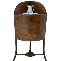 George III mahogany corner washstand, raised back over bowl rests, fitted with five faux drawers and one real with cupboard between, on sabre supports united by undertier, with ceramic bowl and rug